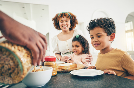 Love, breakfast cereal and happy black family children, mother and father eating meal, bonding and prepare ingredients. Morning food, hands and hungry mom, dad and young youth kids in home kitchen, a Photo by Peopleimages.com