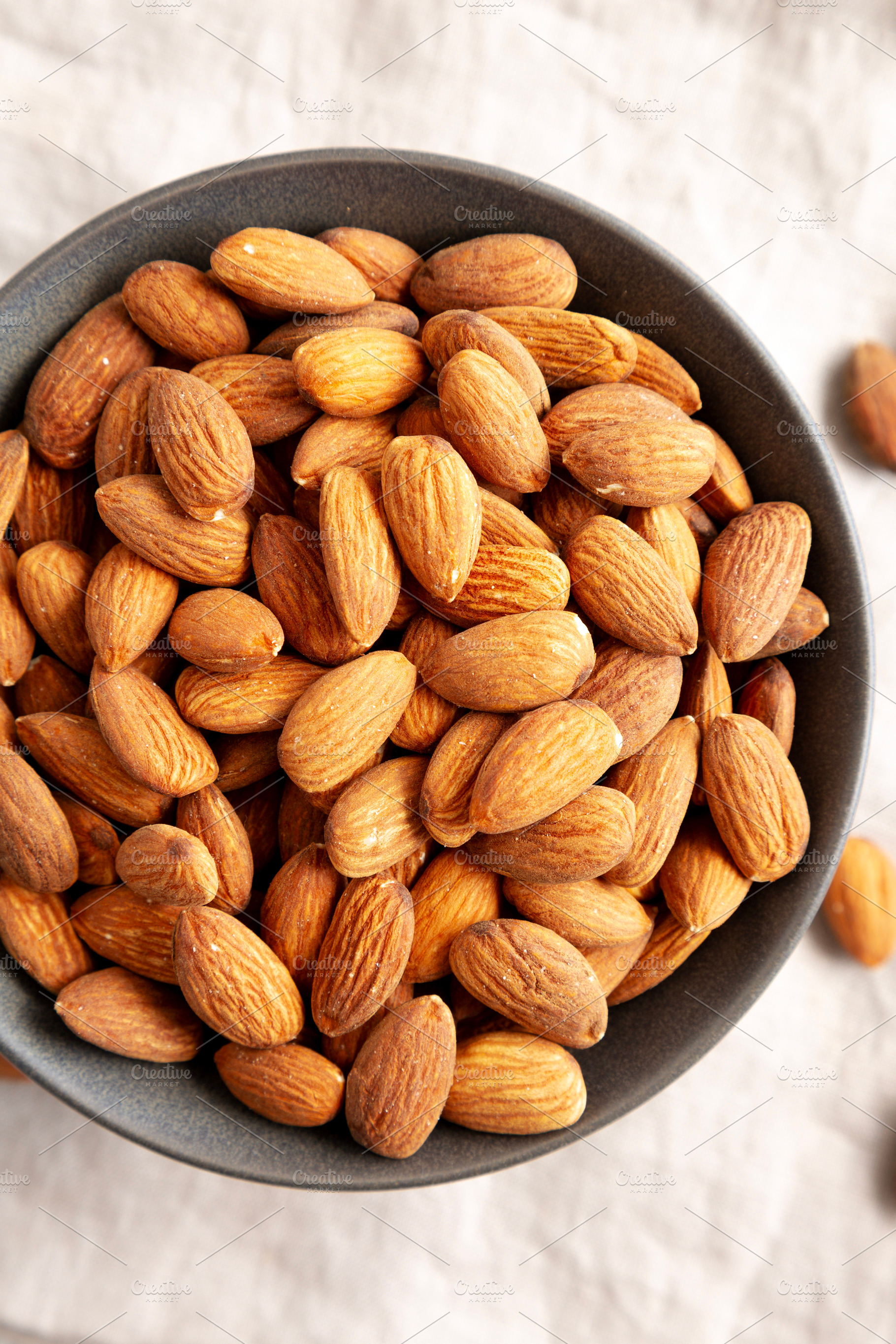 Roasted Almonds in a Bowl, top view. Flat lay, overhead, from ab, a Food & Drink Photo by LiudmylaChuhunova