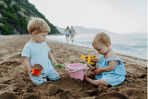 Two toddler children playing on sand, a Person Photo by HalfPoint