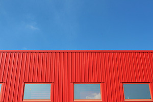 Red building with a blue sky stock photo containing urban and building, an Architecture Photo by The Pixels Factory