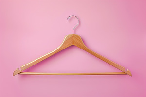 Wooden hanger on pink background, a Photo by AlyaAnd