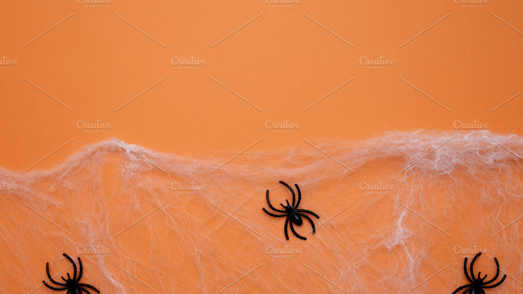 Halloween decoration. Spiderwebs and spiders on orange background, a Photo by matucha