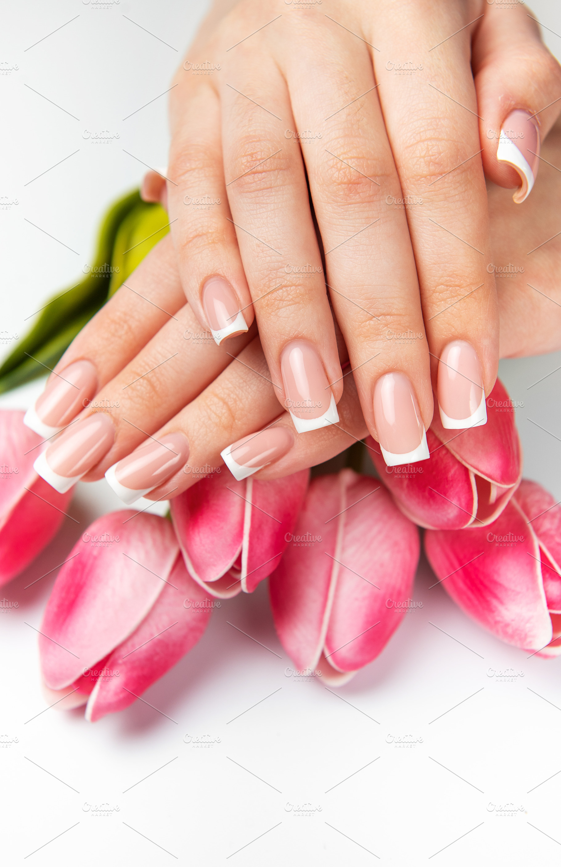 Woman showing french manicure and pink tulips on white backgroun, a Beauty & Fashion Photo by Olena Rudo