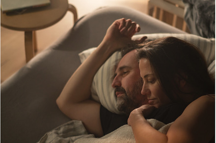 Mid-adult couple lying in bed at, a Person Photo by HalfPoint