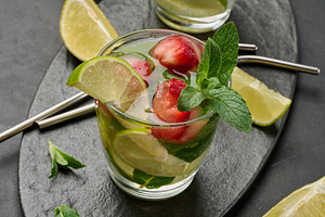 Refreshing mojito cocktail with lime, mint, strawberry, and ice, a Food & Drink Photo by ndanko