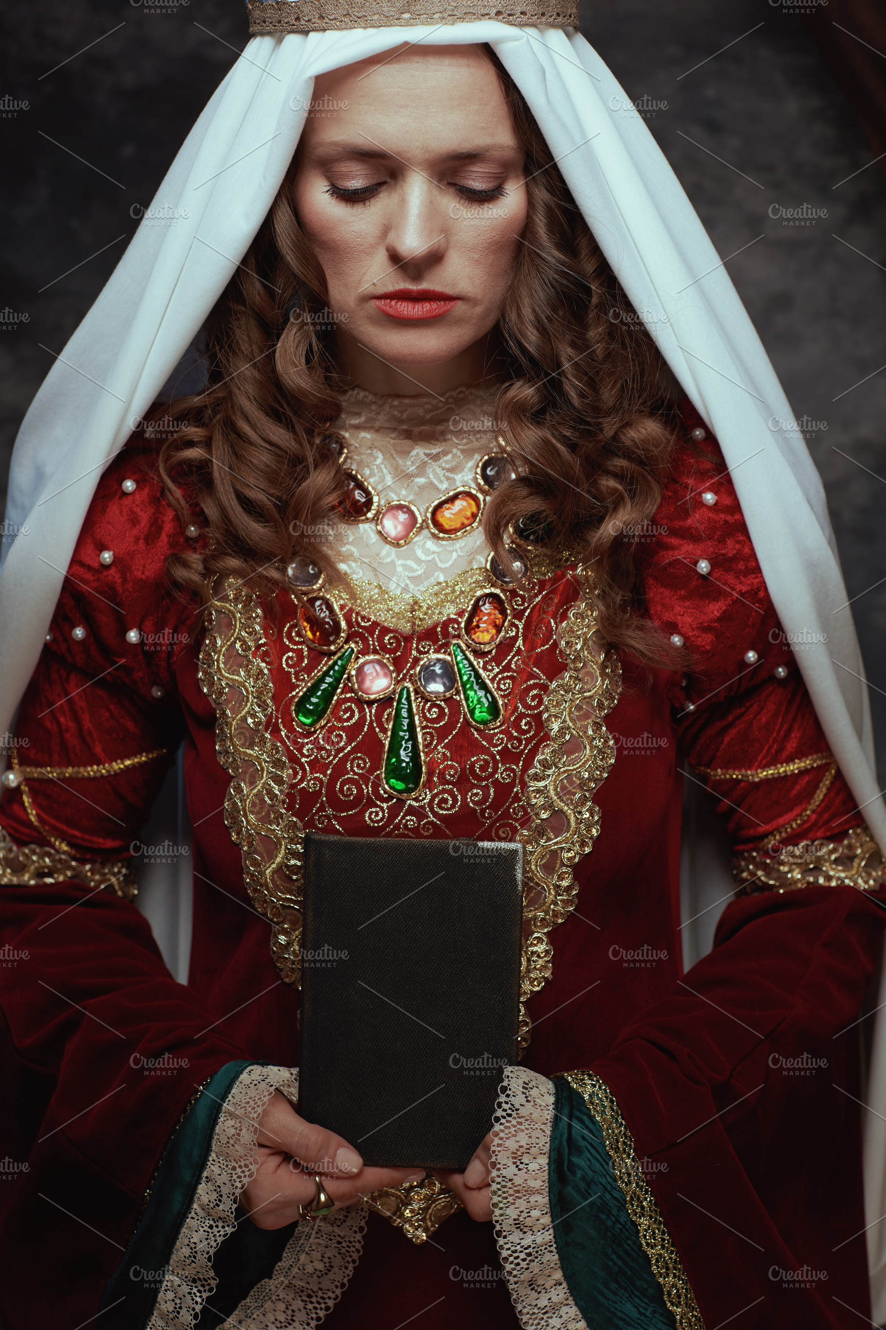 medieval queen in red dress with book and veil, a Person Photo by Alliance Images