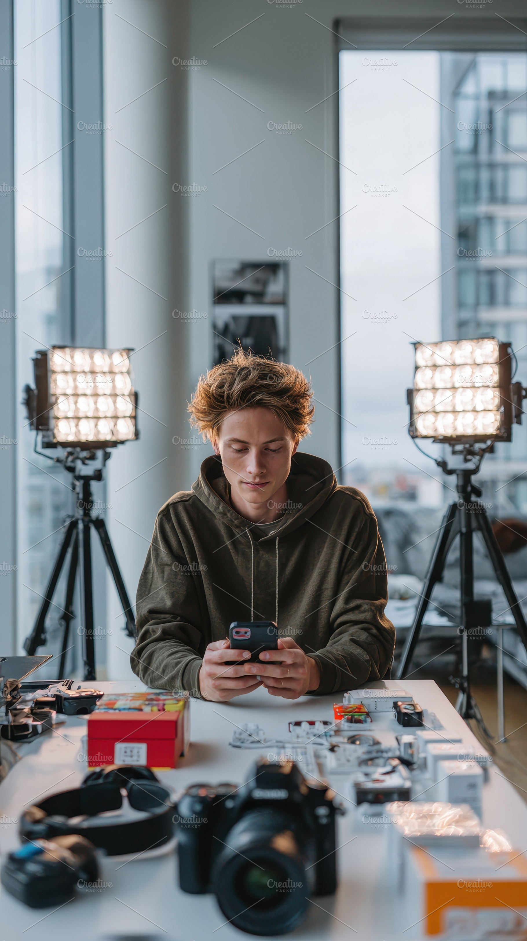 Young man using smartphone in studio, a Photo by Pixeness Studio