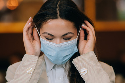 Girl in takes off her protective medical face mask