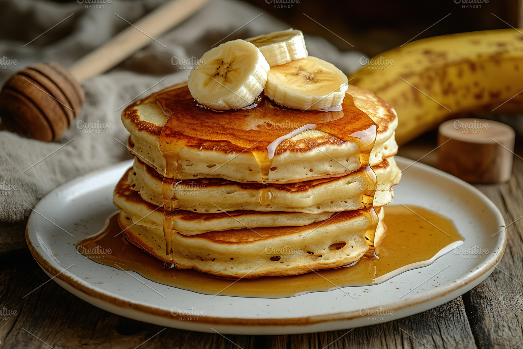 Fluffy pancakes topped with banana slices and drizzled in rich syrup on wooden, a Food & Drink Photo by AlyaAnd