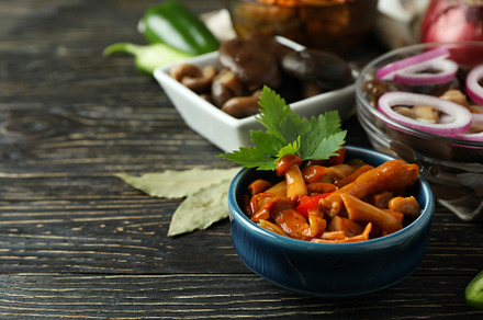 Bowls of marinated mushrooms on rustic wooden table, a Food & Drink Photo by AtlasStudio PRO