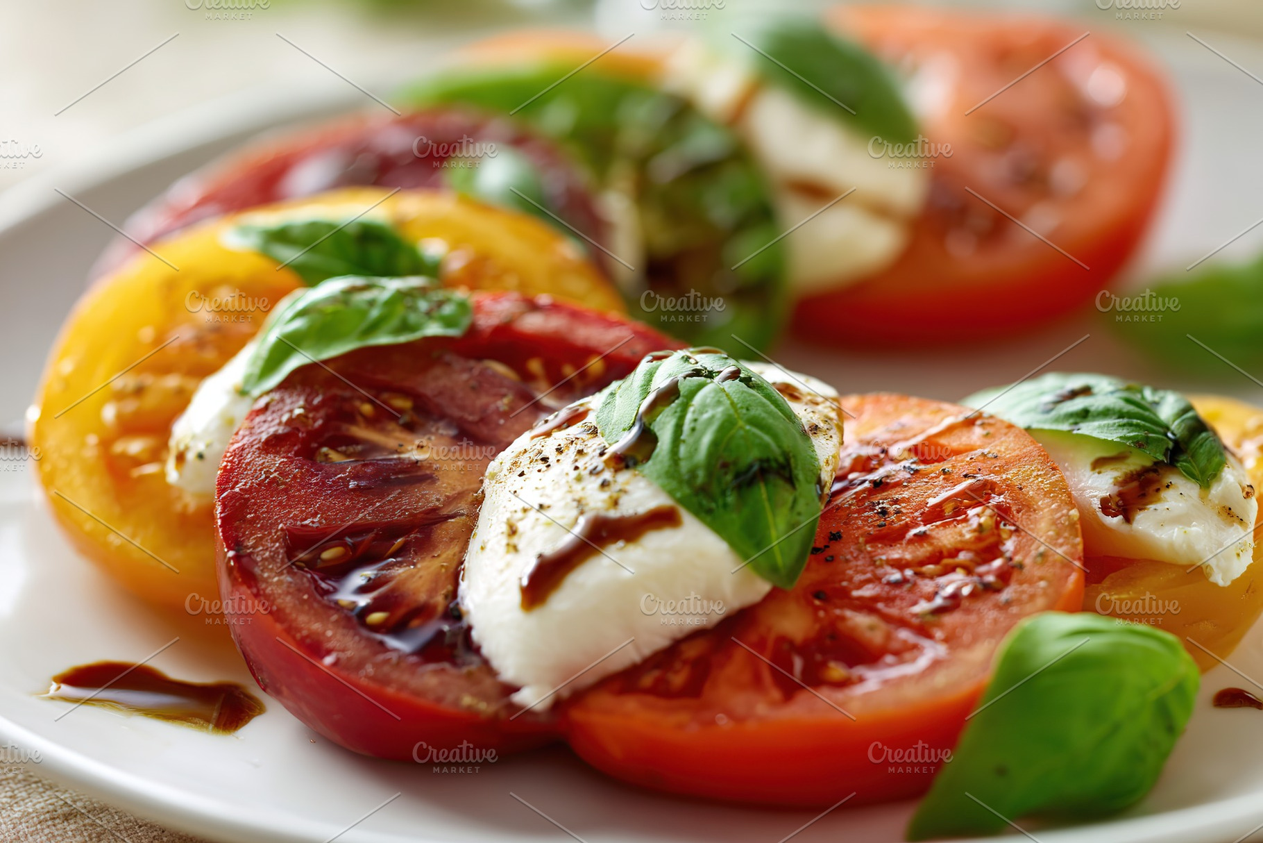 Fresh caprese salad featuring heirloom tomatoes and basil with creamy mozzarell, a Food & Drink Photo by AlyaAnd