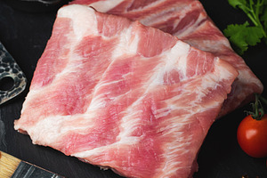 Raw meat. Raw pork ribs from the back with meat on a black background. backgrou, a Food & Drink Photo by Budarinphoto
