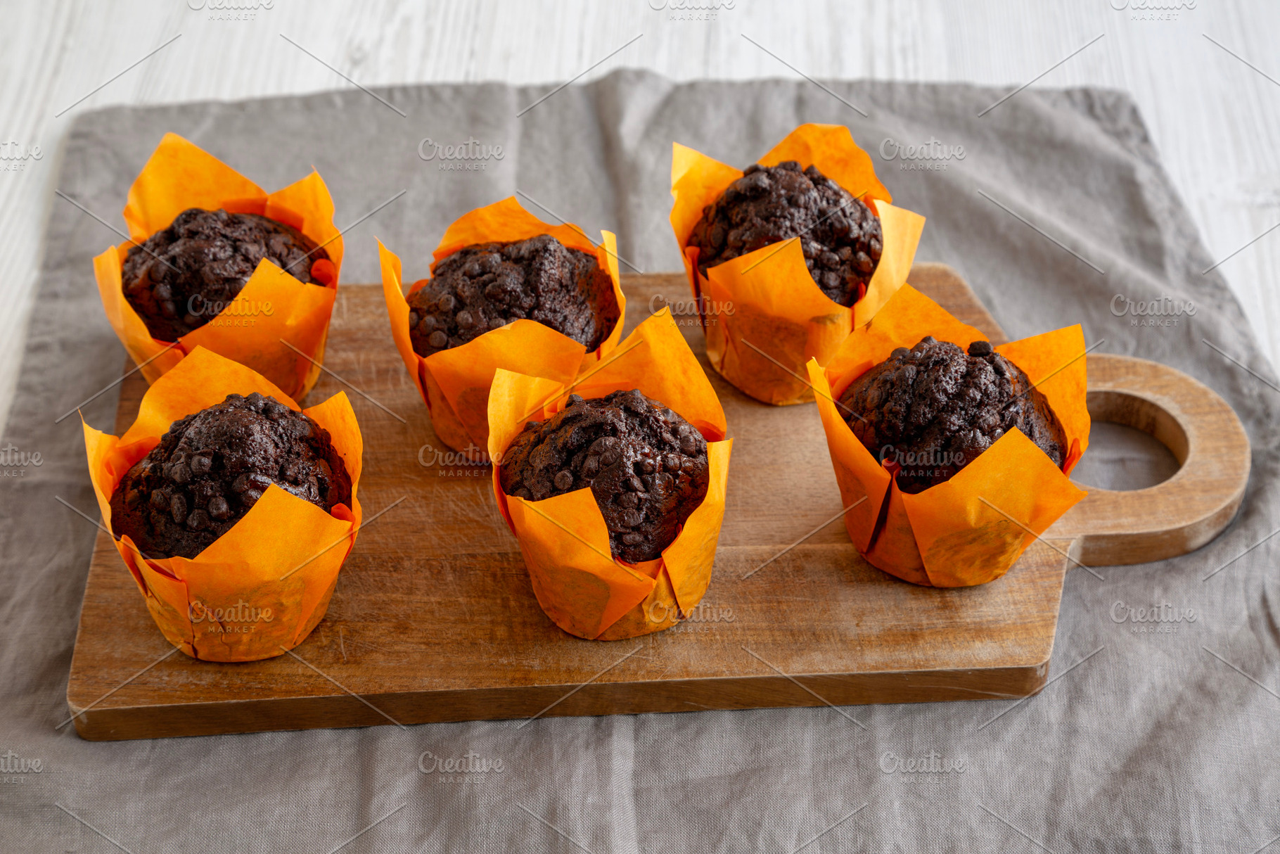 Homemade Chocolate Chip Muffins on a wooden board, side view., a Food & Drink Photo by LiudmylaChuhunova