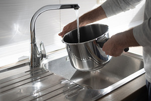 Filling pot with water from kitchen faucet over stainless steel sink, a Food & Drink Photo by etorres69