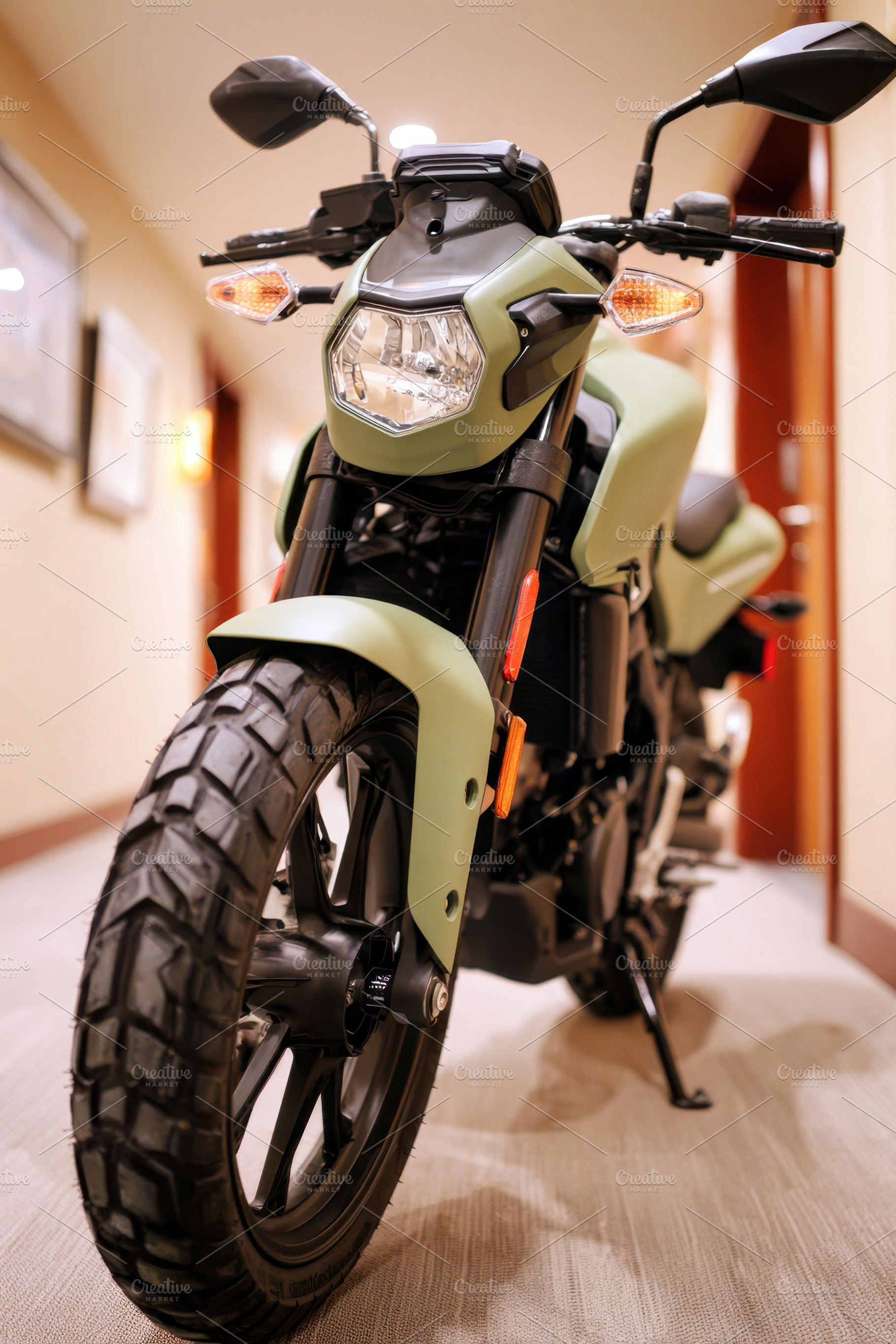 Green motorcycle in hotel hallway, a Transportation Photo by AlyaAnd