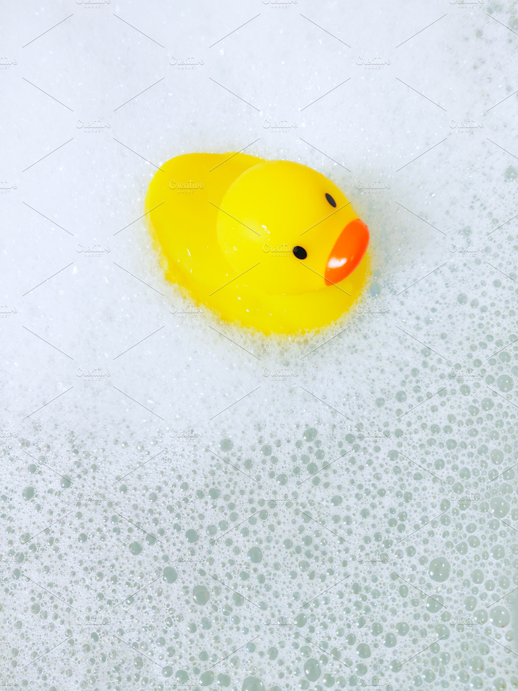 Bathtub with foam bubbles and yellow playful rubber duck in bubb, a Health & Medical Photo by Irina Moskalev