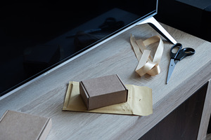 Cardboard box on padded envelope on home workspace table, an Industrial Photo by MDBildes
