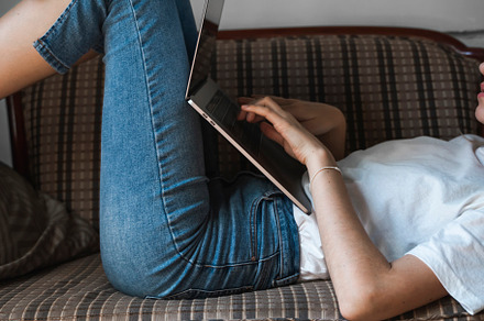 Woman with a laptop laying on a sofa stock photo containing laptop and, a Technology Photo by volodymyrshtun13795