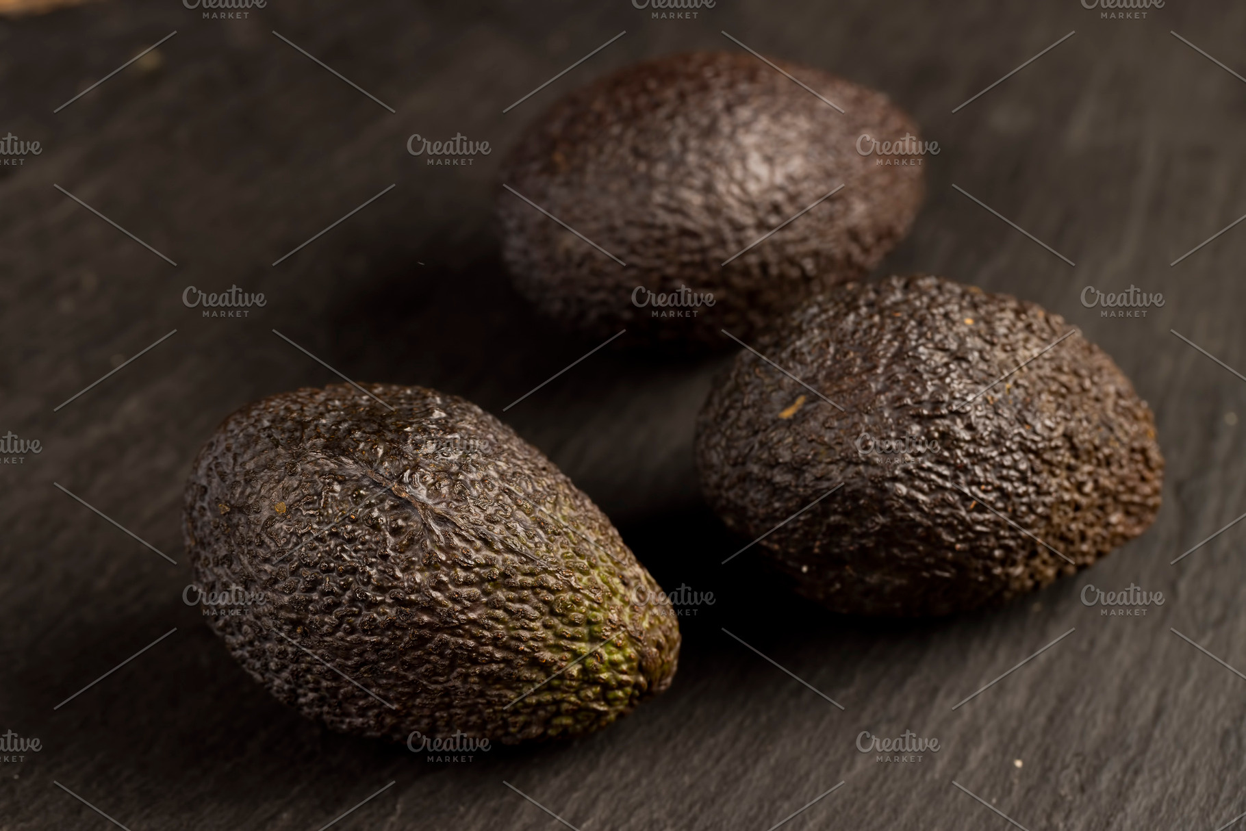 whole avocado fruits of small size on a slate, ripe avocado fruit for cooking,, a Photo by rsoollAI