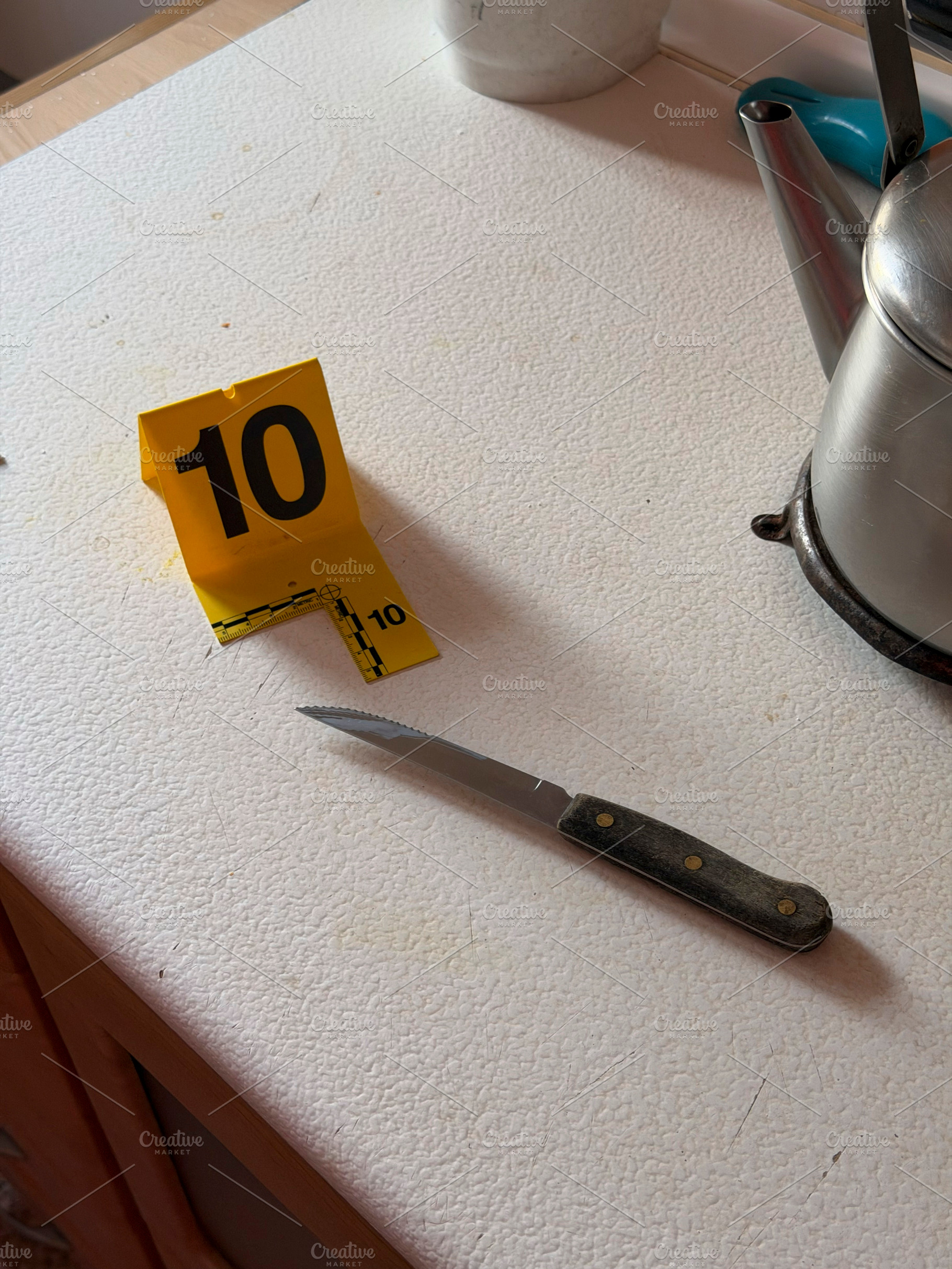 Crime scene evidence marker next to knife at home, an Industrial Photo by karrastock