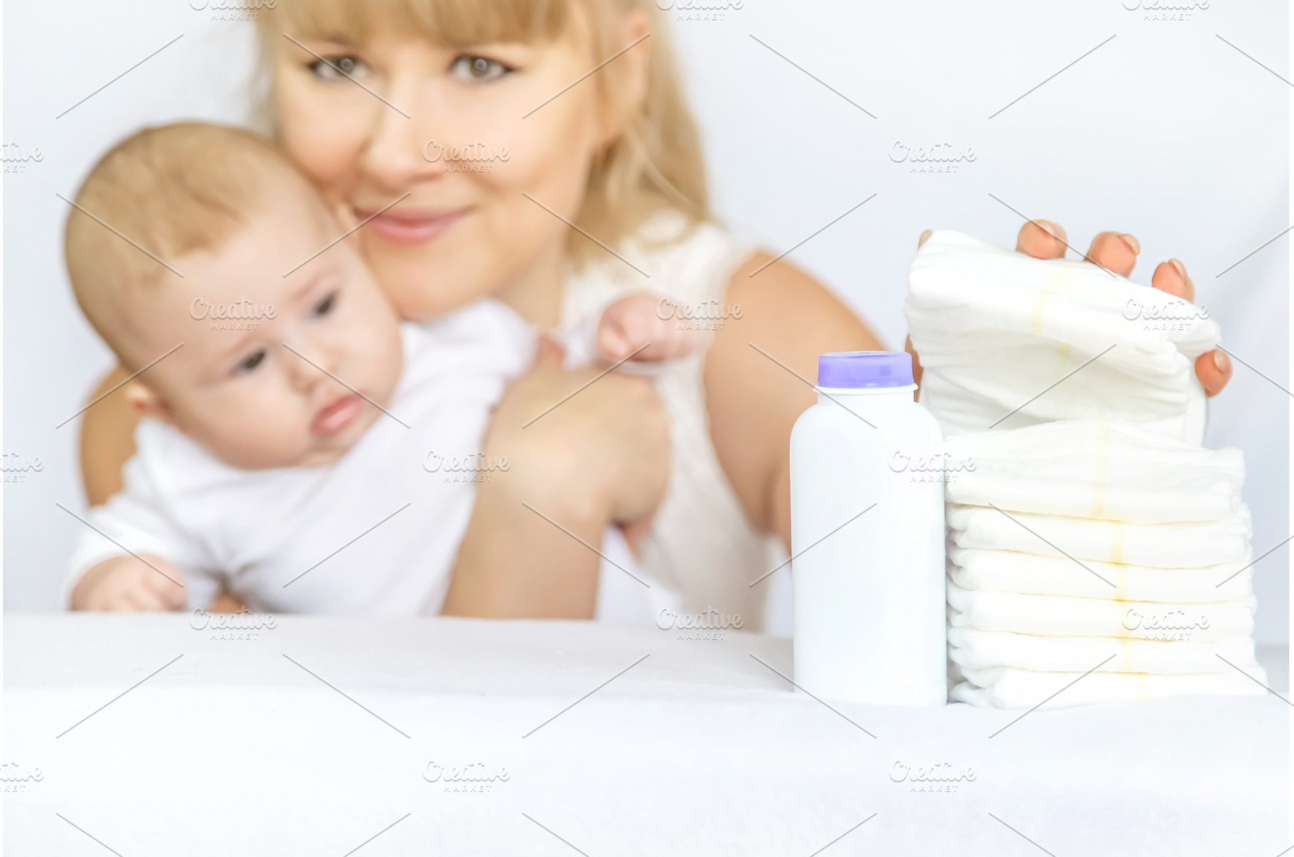 mother changes baby's diaper on a, a Person Photo by yanadjana