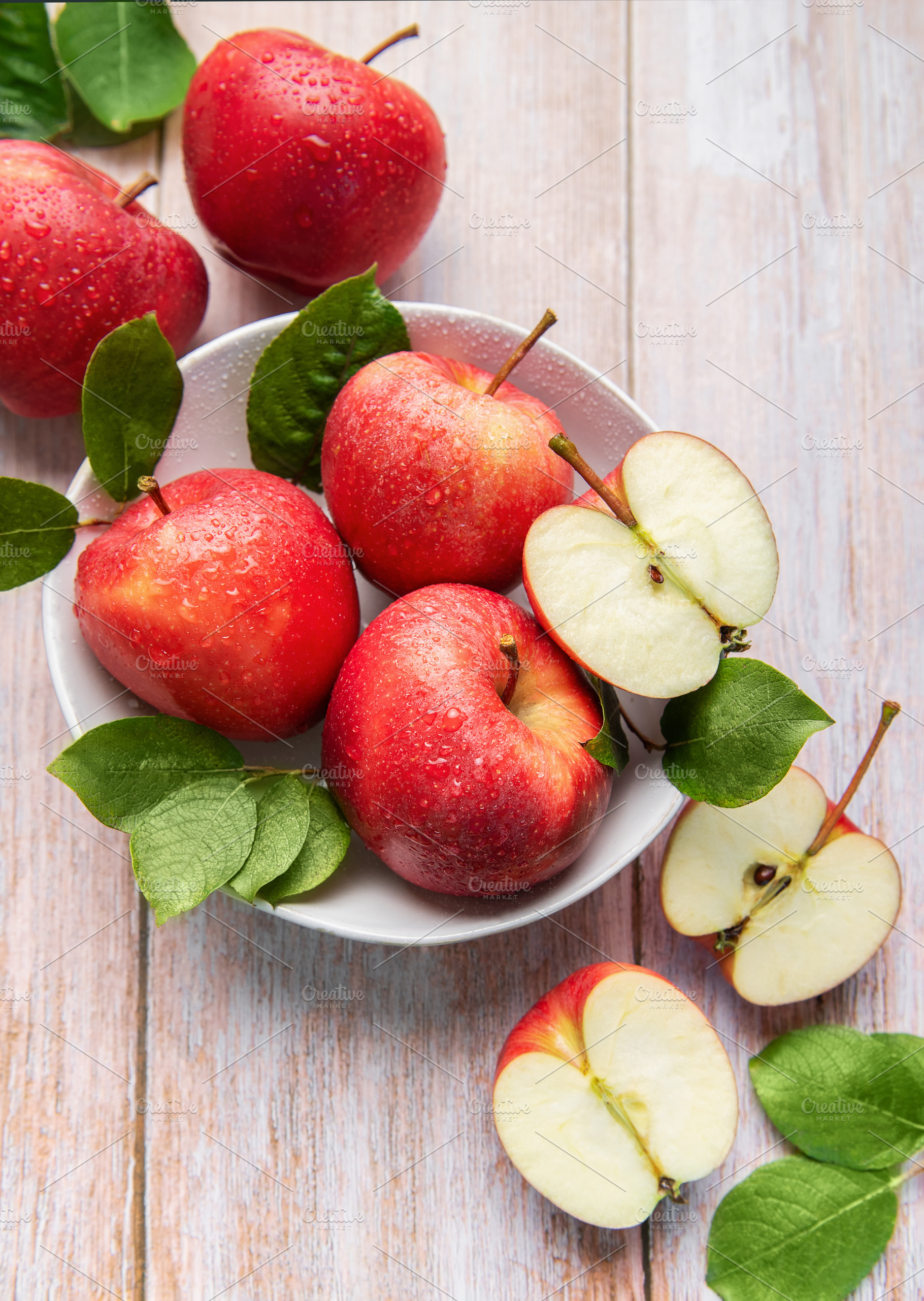 Fresh red apples with water drops and green leaves, a Food & Drink Photo by Olena Rudo