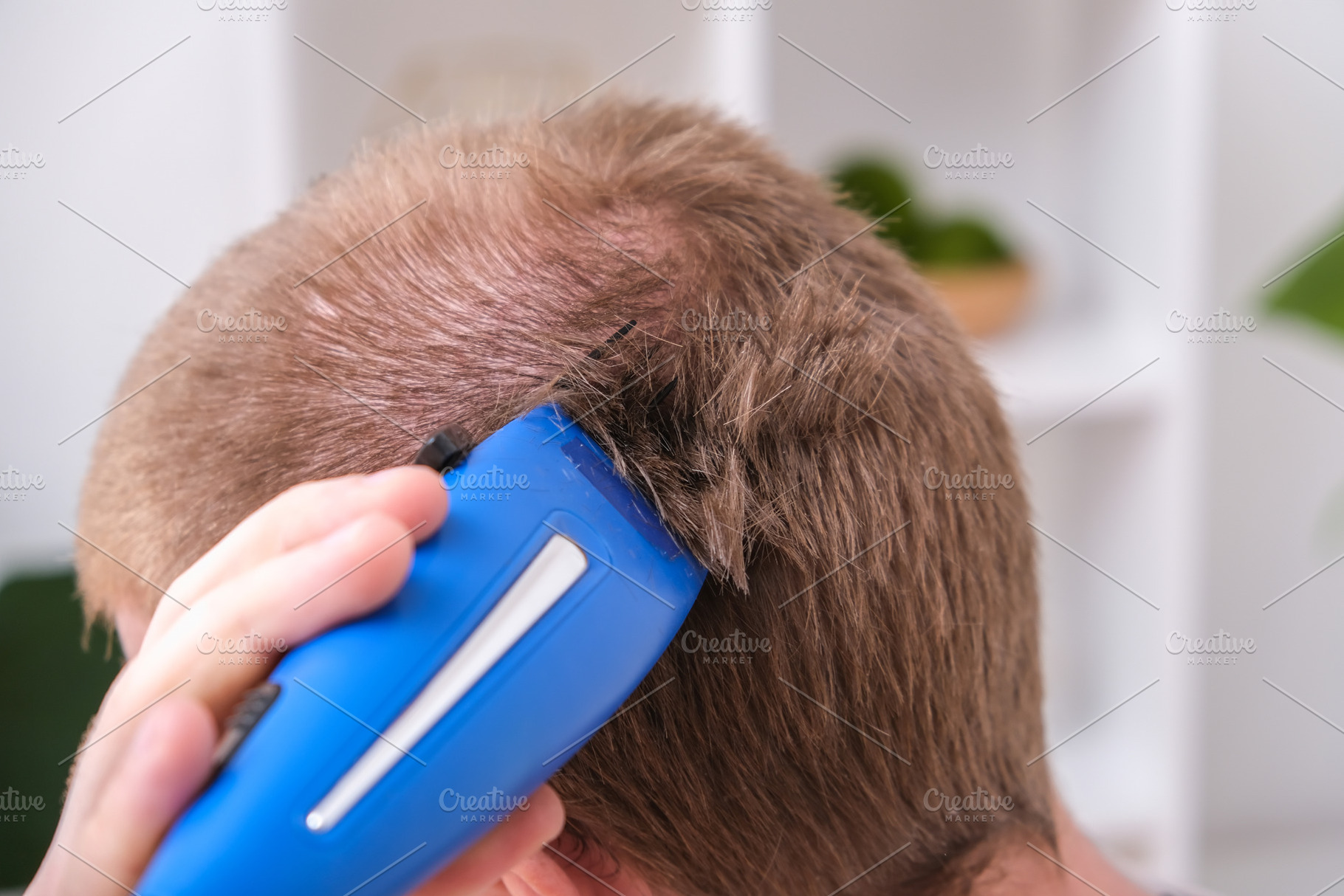 A man cuts his hair with clipper. Cutting a short hairstyle at home. Close-up., a Technology Photo by Detriana