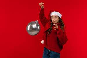 Girl in Santa hat and sweater holds, a Person Photo by Elena Vagengeim