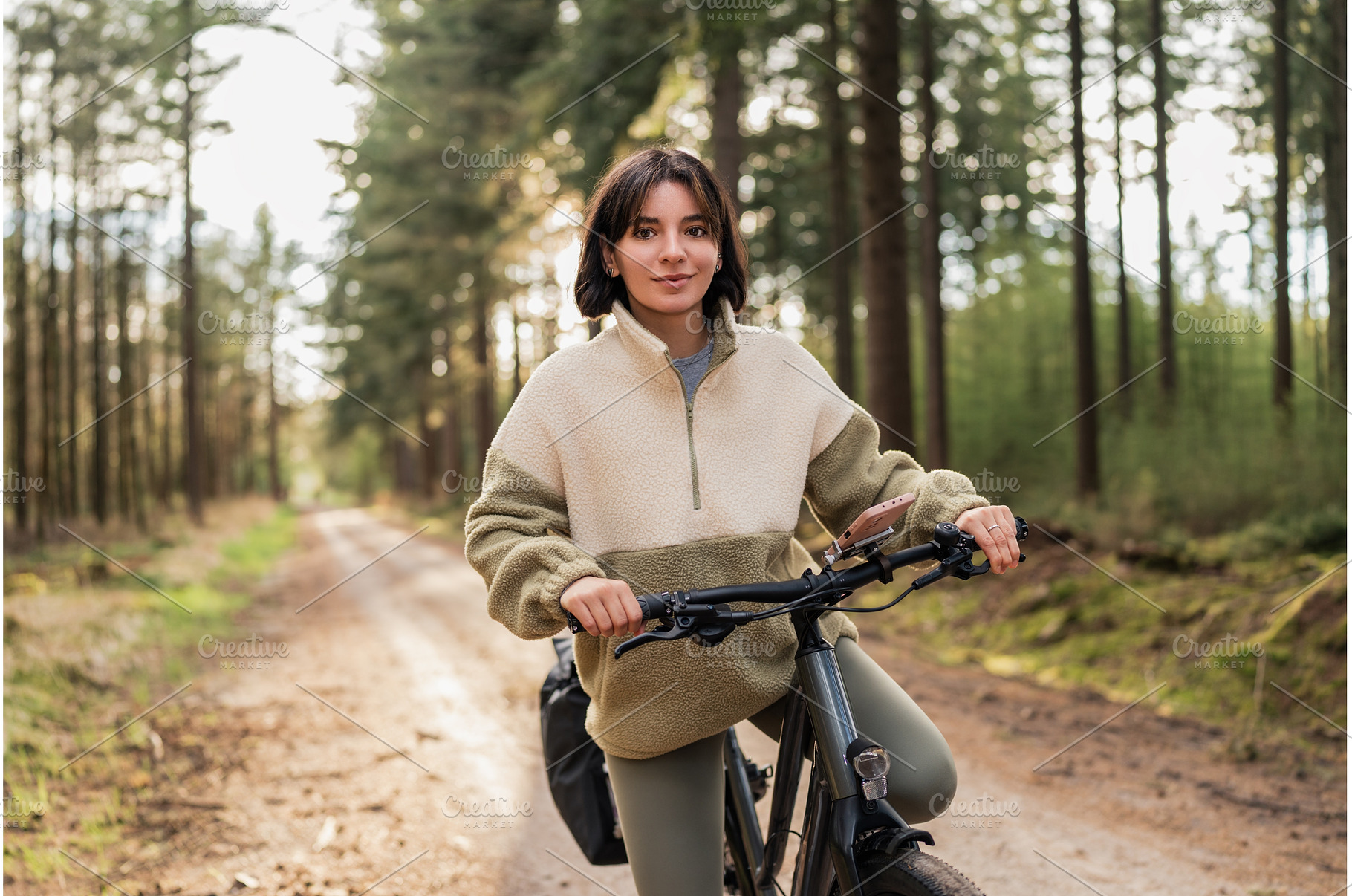 Woman cycling through dense forest, a Holiday Photo by AD Stock Images