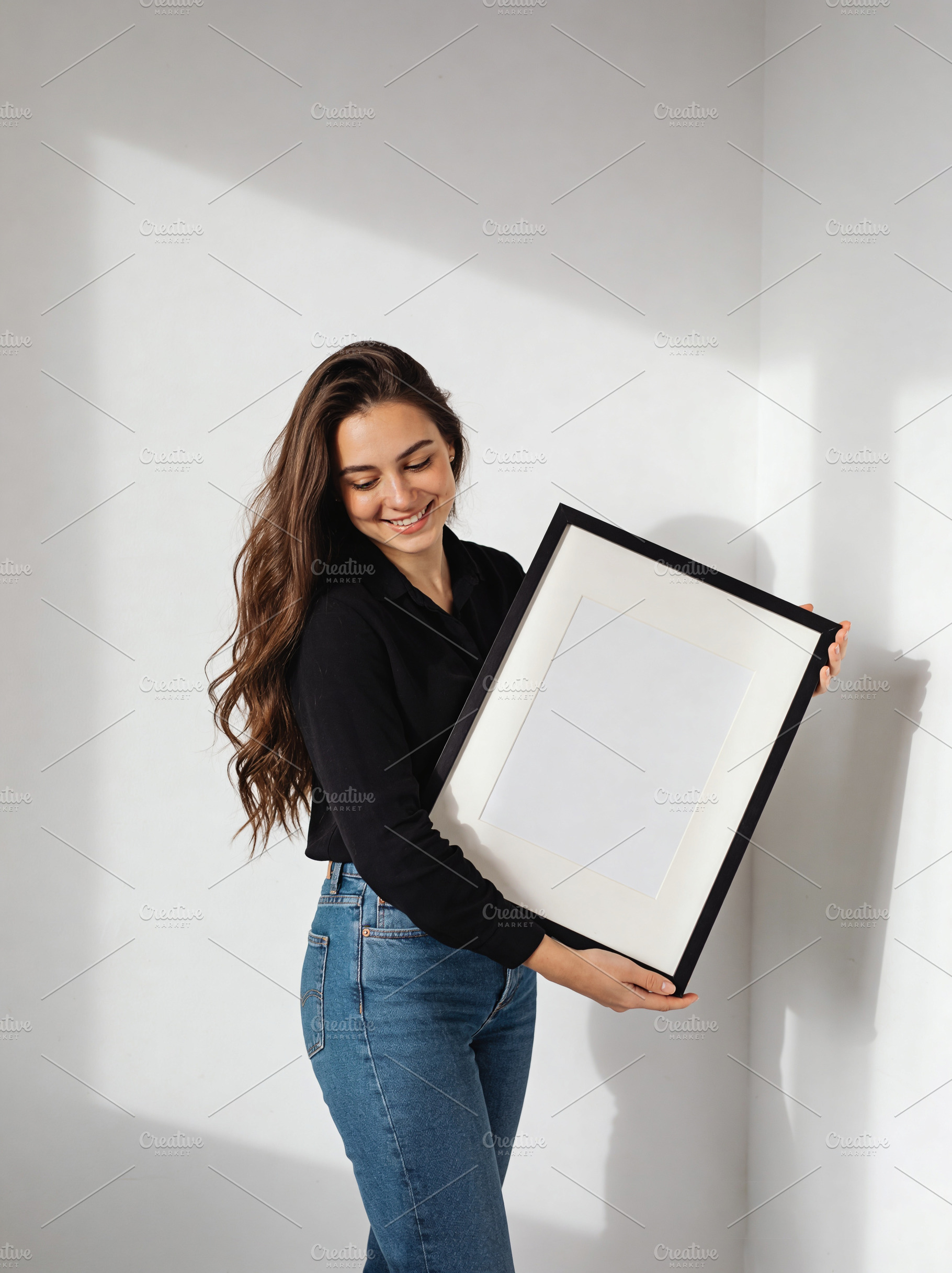 Woman holding blank picture frame, an Architecture Photo by Virgo Studio