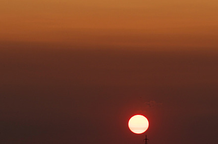 Bright sun sets above horizon