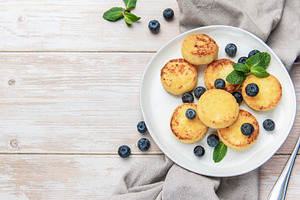 Syrniki cheese pancakes with fresh blueberries and mint, a Food & Drink Photo by Olena Rudo