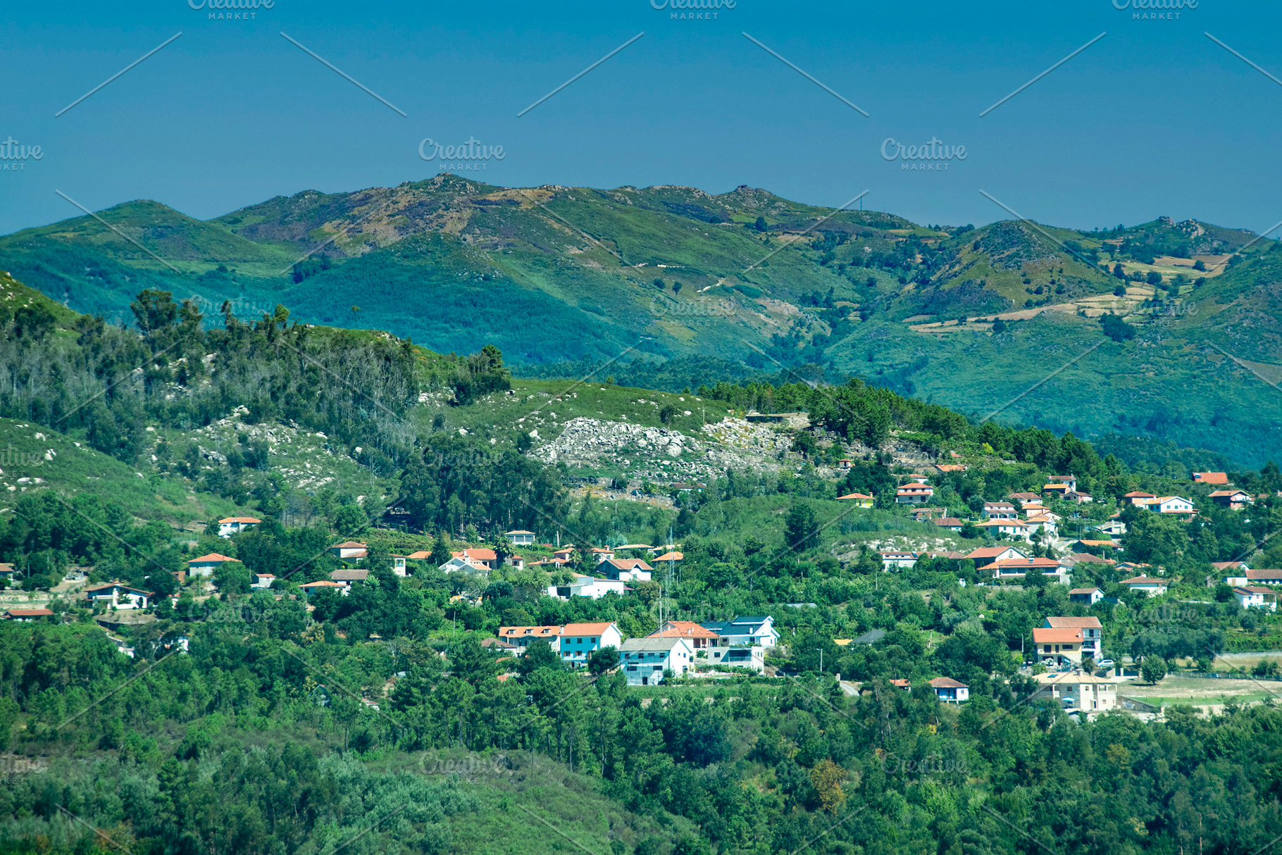 Mountain village with clustered homes among trees, a Transportation Photo by DanFLCreativo