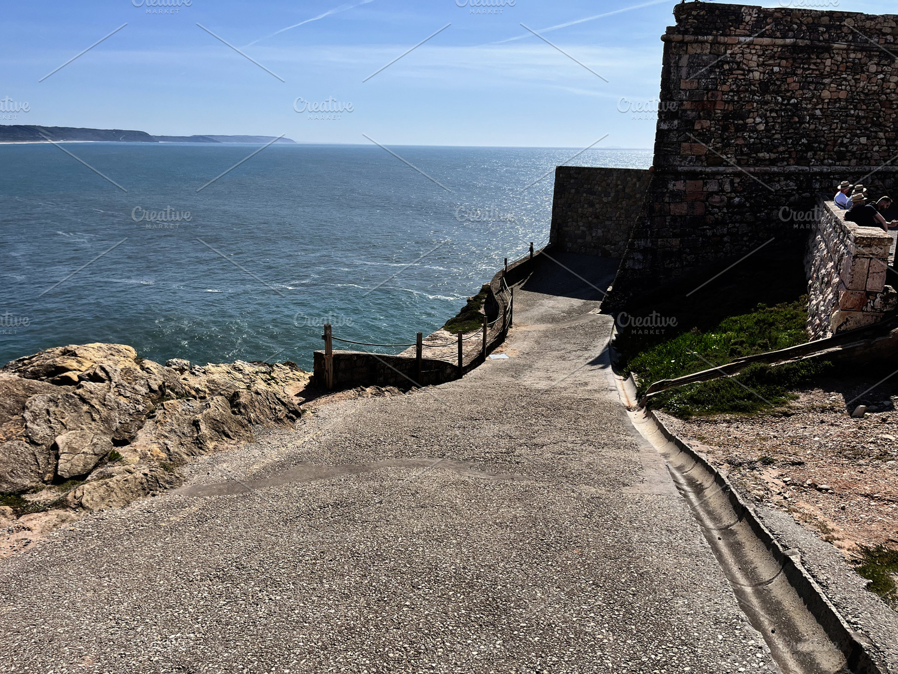 Coastal pathway leading to fort with ocean view in Nazare, Portugal, a Photo by AS photostudio