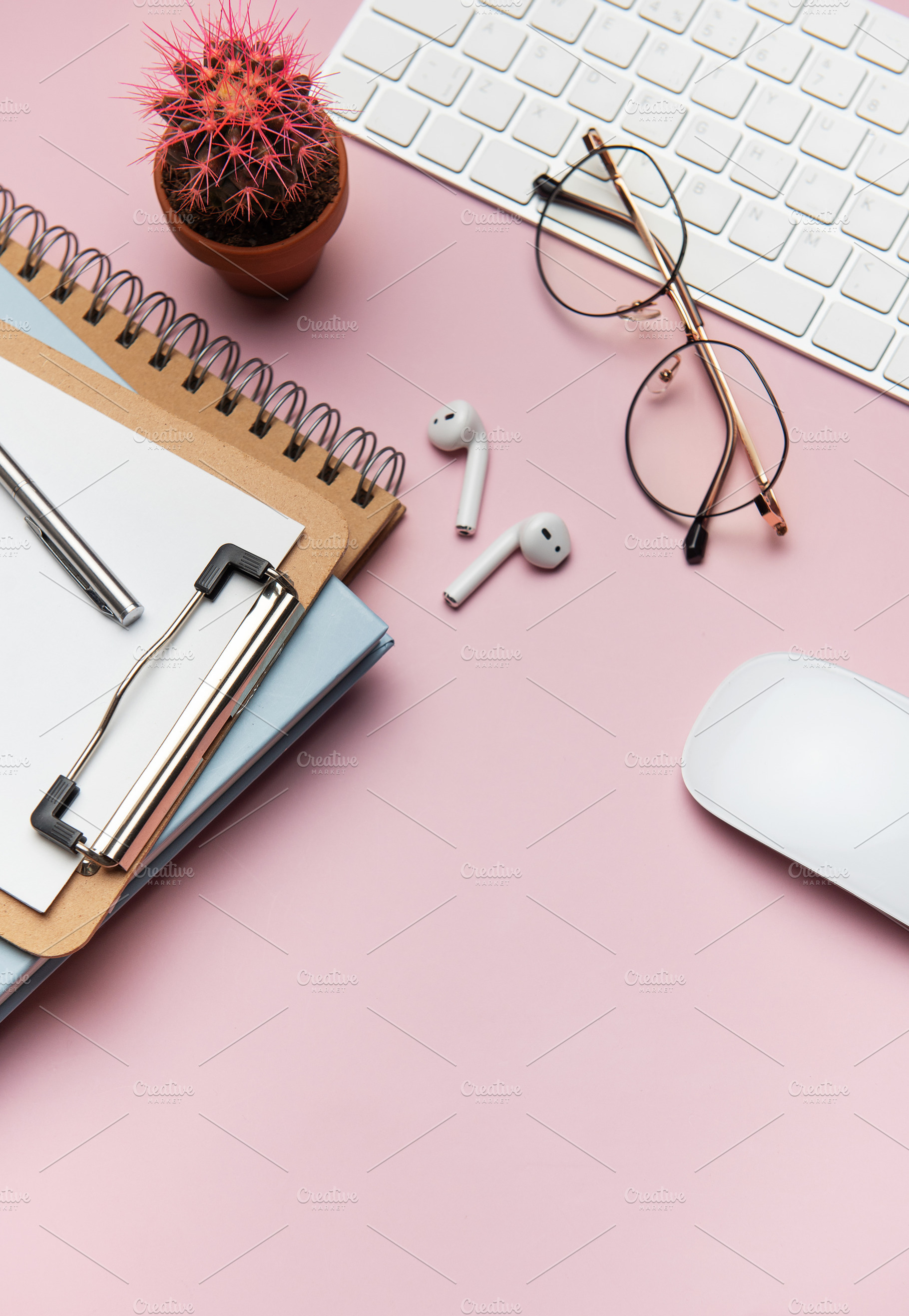 Workspace organizing accessories on pink table with plant and ke, a Business Photo by Olena Rudo