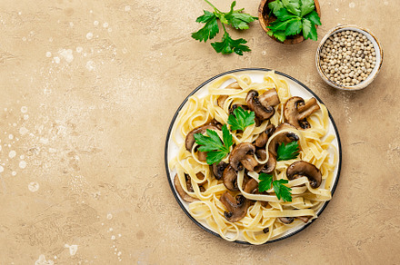 Delicious pasta with champignon mushrooms on plate with parsley, a Food & Drink Photo by 5PH