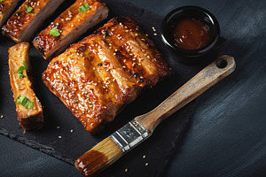 Barbecue pork spare ribs with hot honey chili marinade on black background, a Food & Drink Photo by Budarinphoto