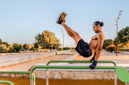 Man doing calisthenics on parallel b, a Sports & Recreation Photo by Perpis