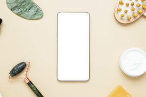 Smartphone display showcasing skincare products arranged with marble face rolle, a Photo by matucha