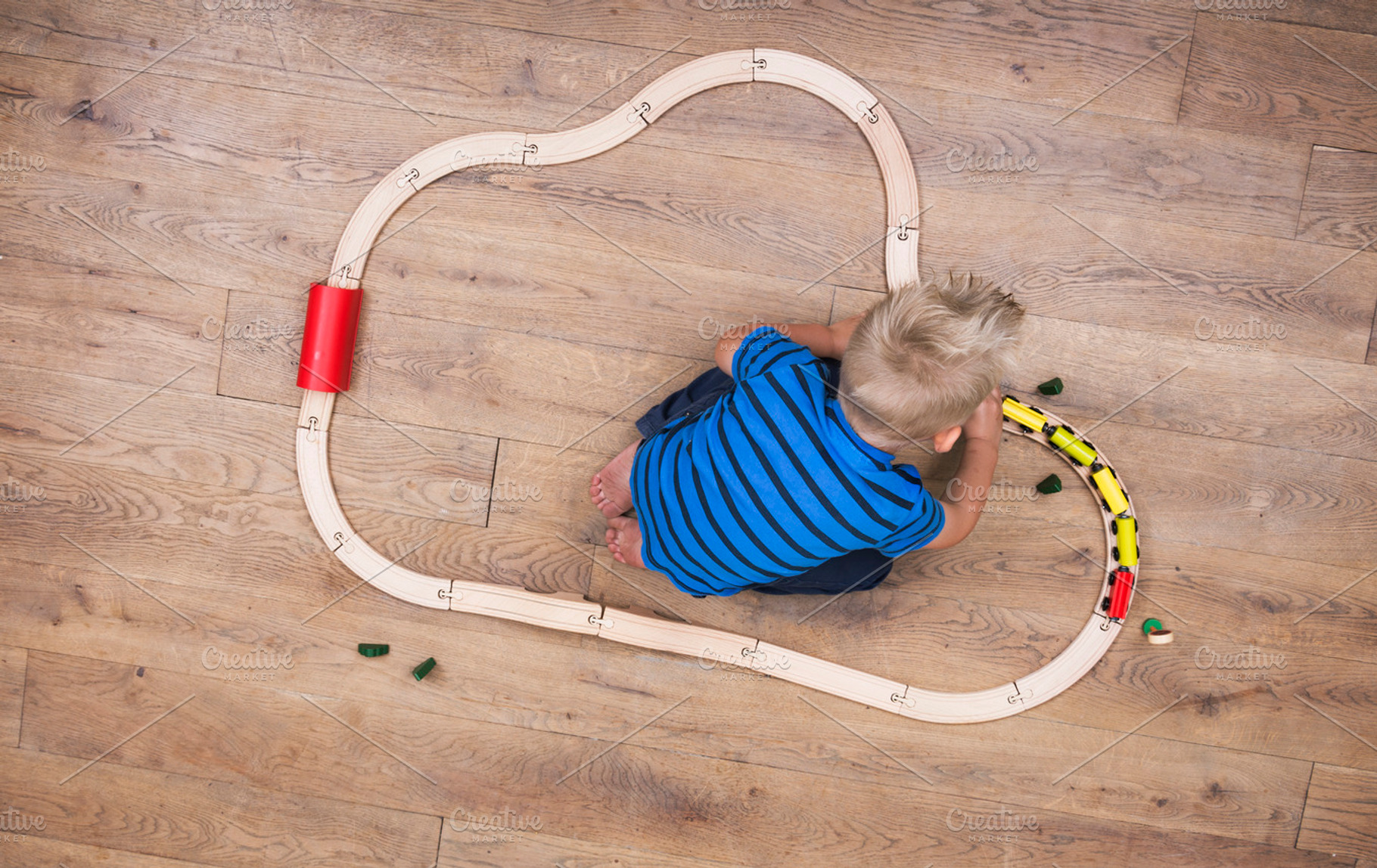 Boy playing with his train set, a Person Photo by Twin Design