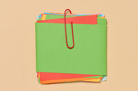 Stack of multi-colored sticky notes secured with a red paper cli, a Beauty & Fashion Photo by ndanko