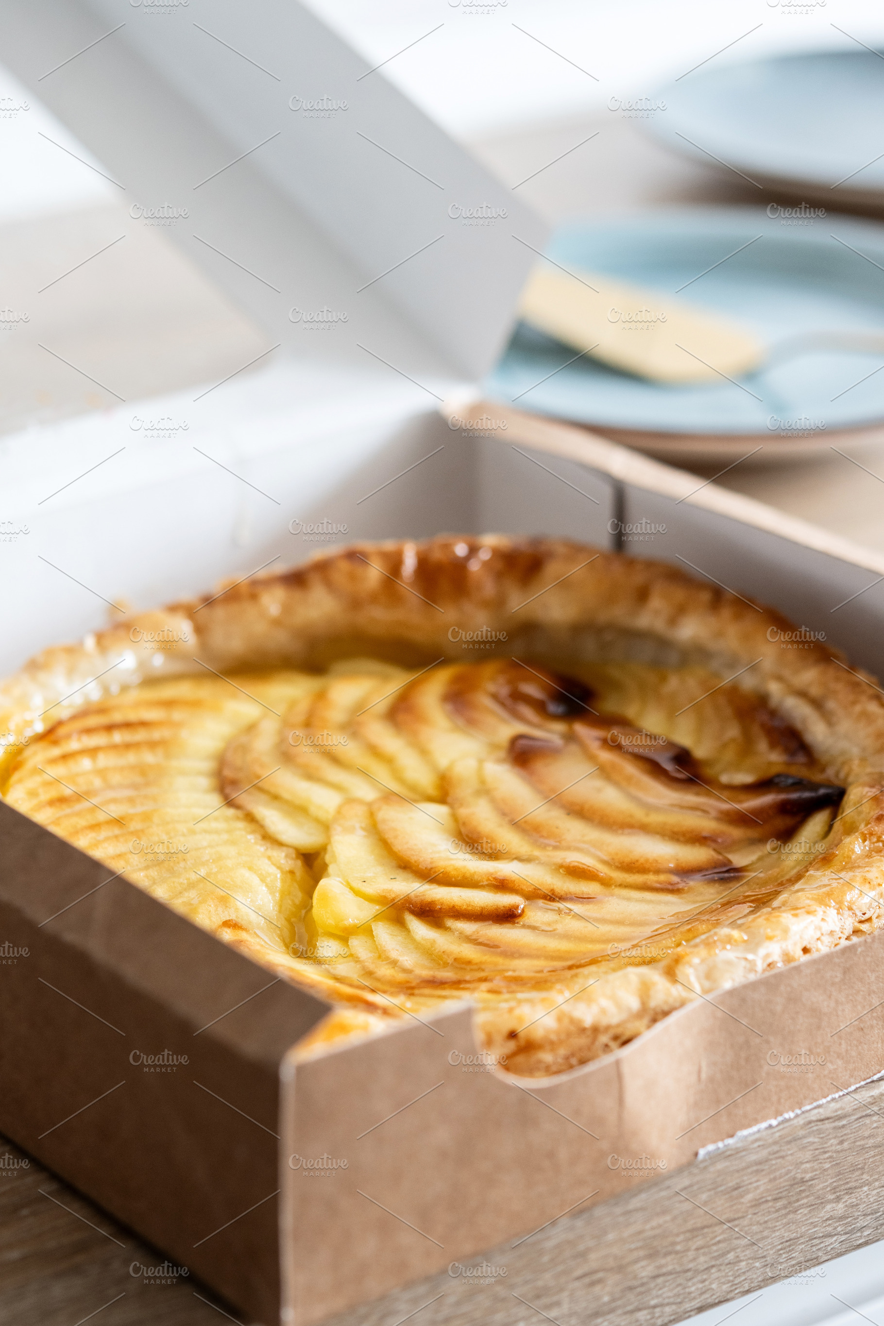 Fresh apple puff pastry tart in cardboard bakery box, a Photo by etorres69