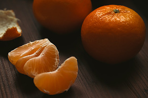 Fresh peeled tangerine segments and whole mandarin oranges showing citrus fruit, a Photo by Studio ANNA