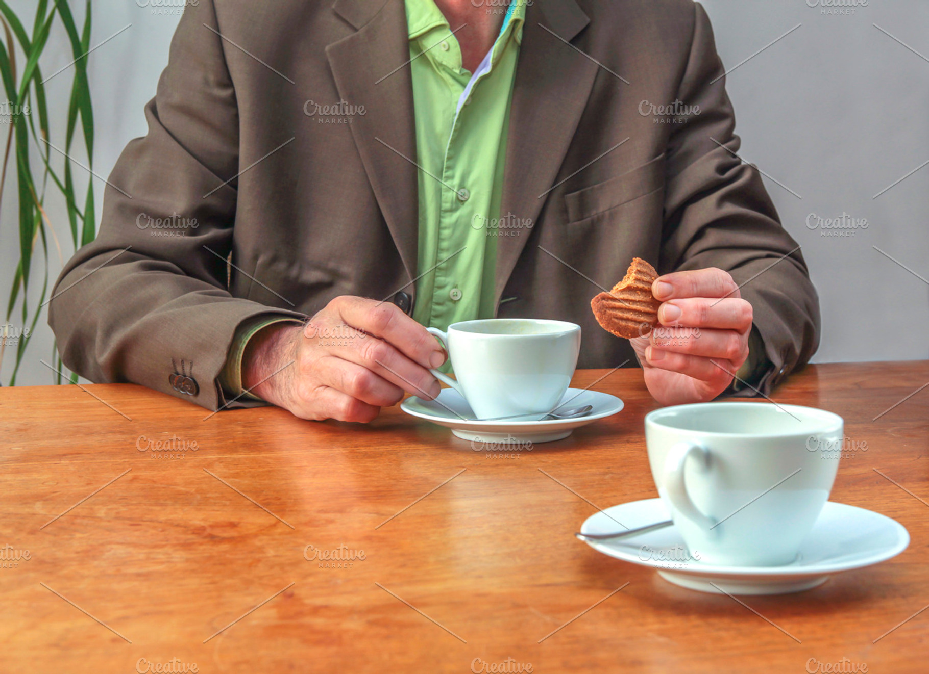 Man drinking coffee and eating cooki