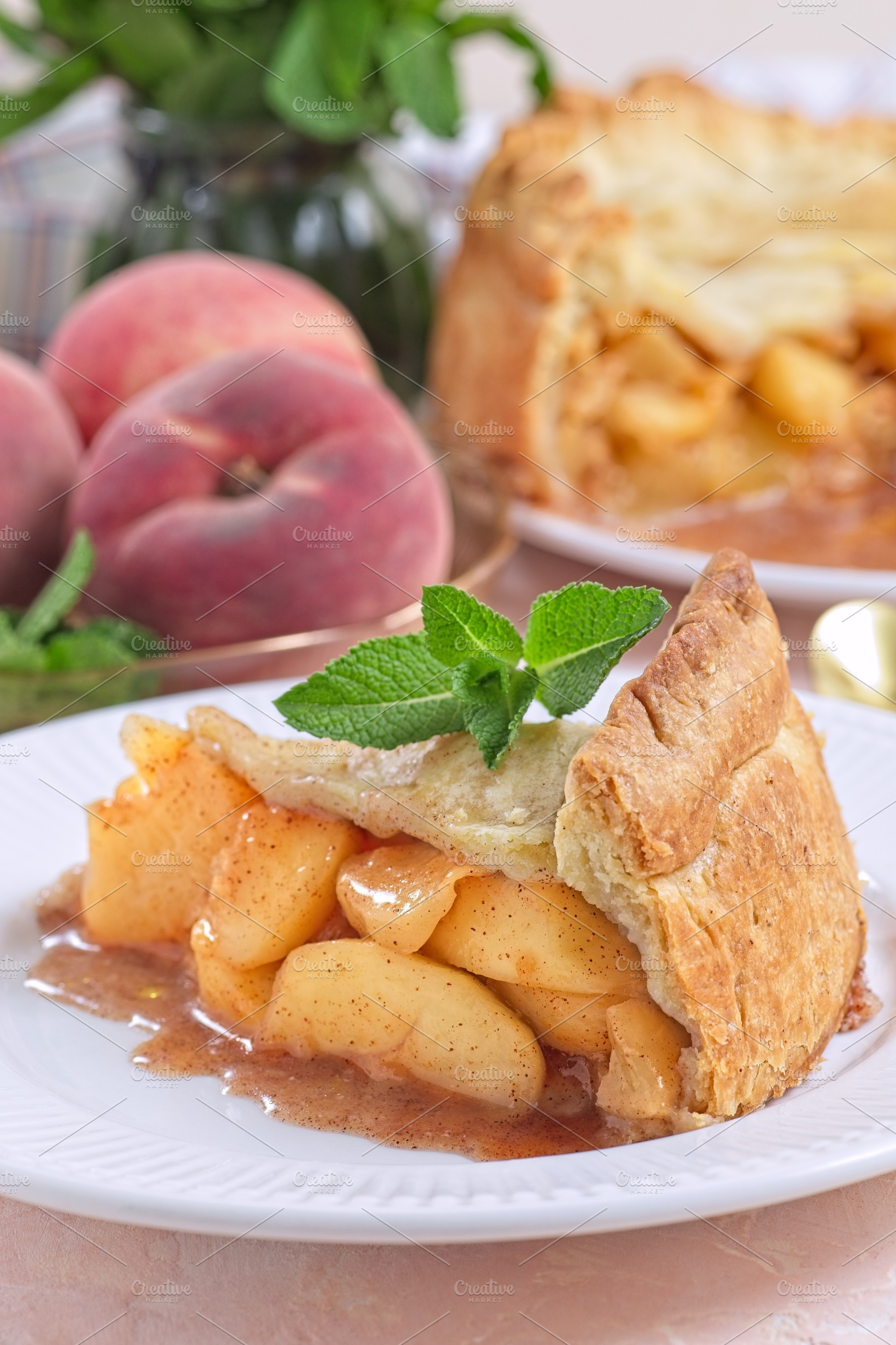 Delicious peach pie slice garnished with fresh mint, on white plate, vertical, a Food & Drink Photo by iuliia_n