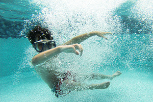 Boy swimming underwater stock photo containing bubbles and pool