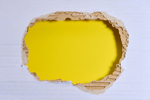 A torn hole in white paper with a yellow background inside., a Background Photo by ndanko