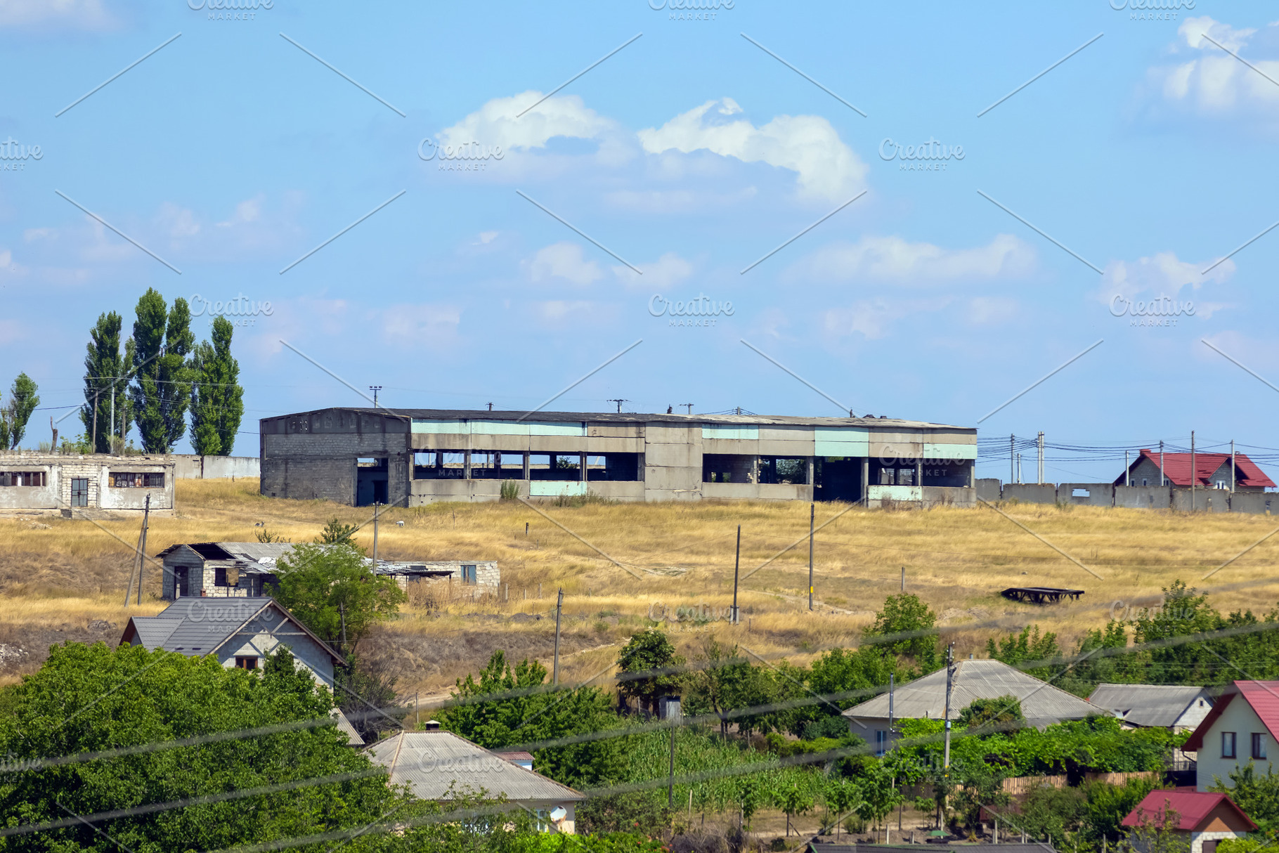 Old concrete warehouse in a rural area surrounded by dry grass,, an Architecture Photo by Ales Munt
