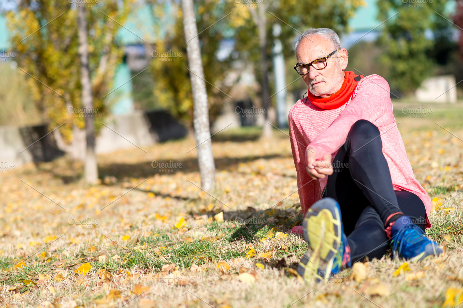 Senior man stretching on the grass during outdoor exercise, a Sports & Recreation Photo by RF Images