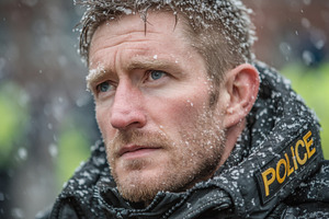 Serious police officer in uniform standing outdoors during snowfall in winter s, a Photo by AS photostudio